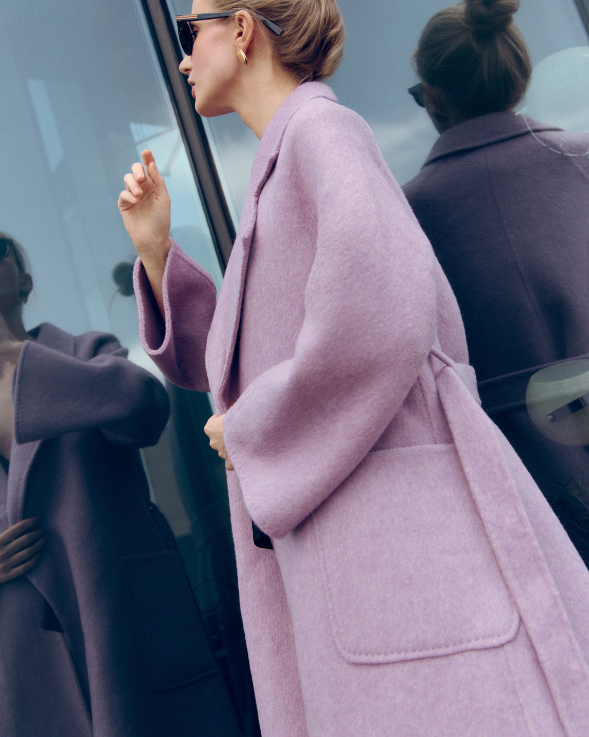 Lavender wool-cashmere robe coat with wide lapels, self-tie belt, and oversized silhouette. Soft brushed texture and elegant drape for modern layering