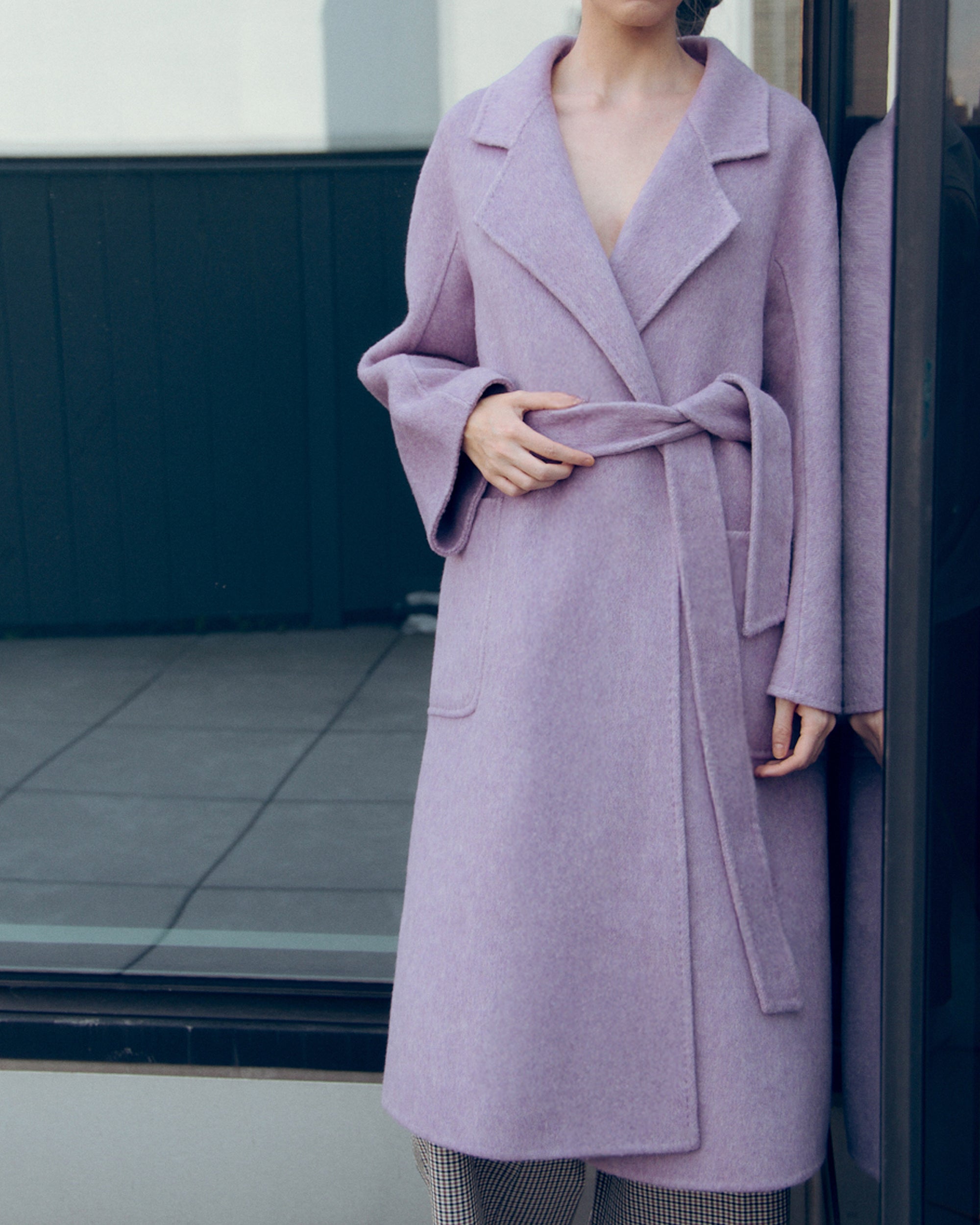 Lavender wool-cashmere robe coat with wide lapels, self-tie belt, and oversized silhouette. Soft brushed texture and elegant drape for modern layering